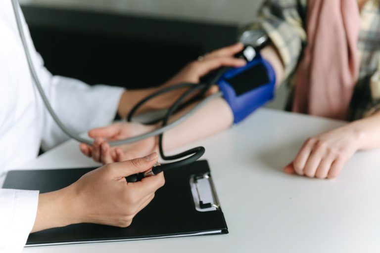 a healthcare worker measuring a patient s blood pressure using a sphygmomanometer